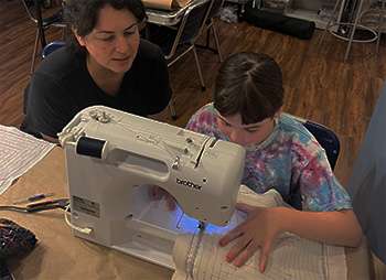 Sewing teacher Elaine Escobar with a student.